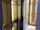 Modern walk-in closet with glass doors and ample lighting