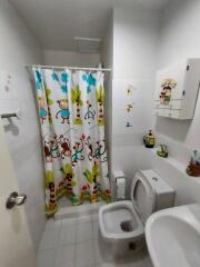 Bathroom with colorful shower curtain and white fixtures