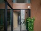 Modern building entrance with glass doors and indoor plants