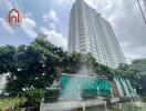 High-rise residential building with water feature and green landscaping