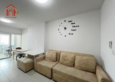 Living room with beige sofa and wall clock