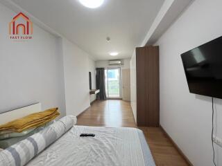 Modern bedroom with TV, balcony access, and wooden flooring