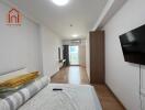 Modern bedroom with TV, balcony access, and wooden flooring