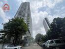 Tall residential building with parking space and trees