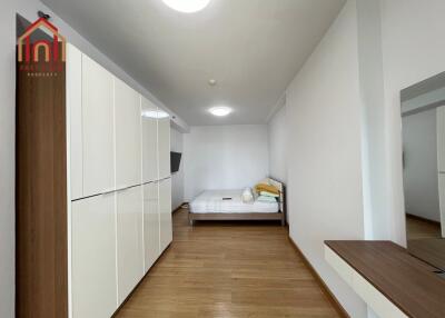 well-lit bedroom with wooden flooring and modern wardrobe