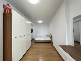 well-lit bedroom with wooden flooring and modern wardrobe