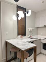 Modern kitchen with pendant lighting and marble countertop