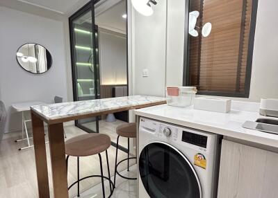 Modern kitchen with high-top table and washing machine