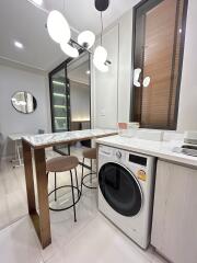 Modern kitchen with high-top table and washing machine