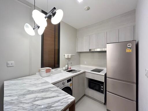 Modern kitchen with marble countertop and stainless steel appliances