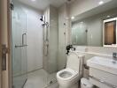 Modern bathroom with glass shower, toilet, and sink