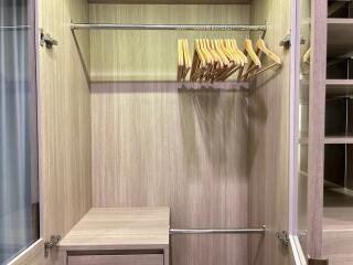 Empty wooden closet with hangers and drawers