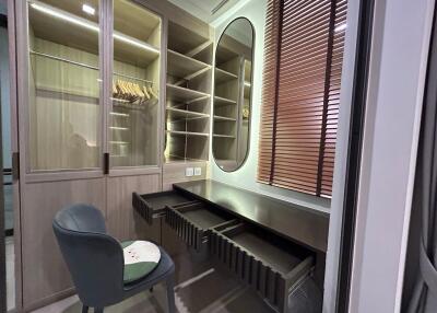 Walk-in closet with mirror and seating area