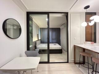 Modern living area with view into a bedroom through a glass partition