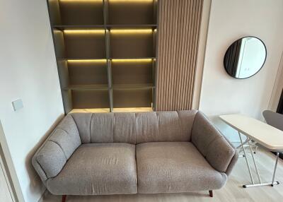 Modern living room with a grey sofa and wall-mounted shelving