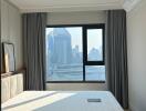 Spacious bedroom with a large window offering a city view