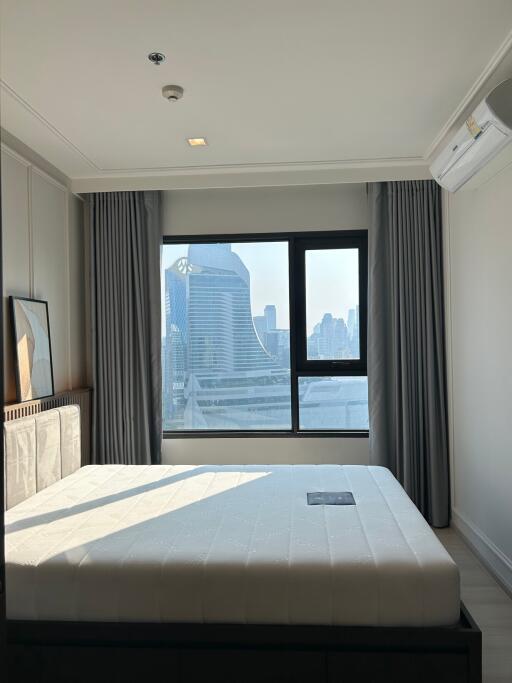 Spacious bedroom with a large window offering a city view