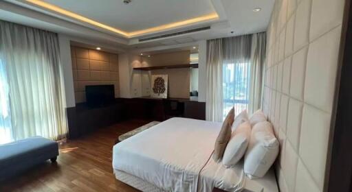 Spacious bedroom with double bed, hardwood floors, large windows, and modern lighting