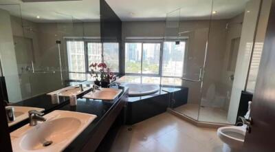 Modern bathroom with city view, featuring dual sinks, bathtub, and glass shower