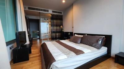 Modern bedroom with wooden flooring and a large bed