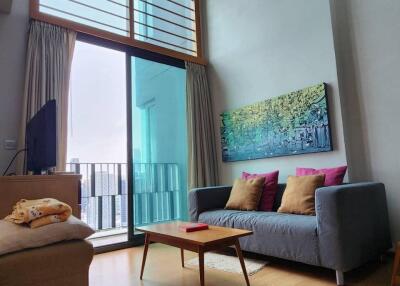 High-ceilinged modern living room with large windows