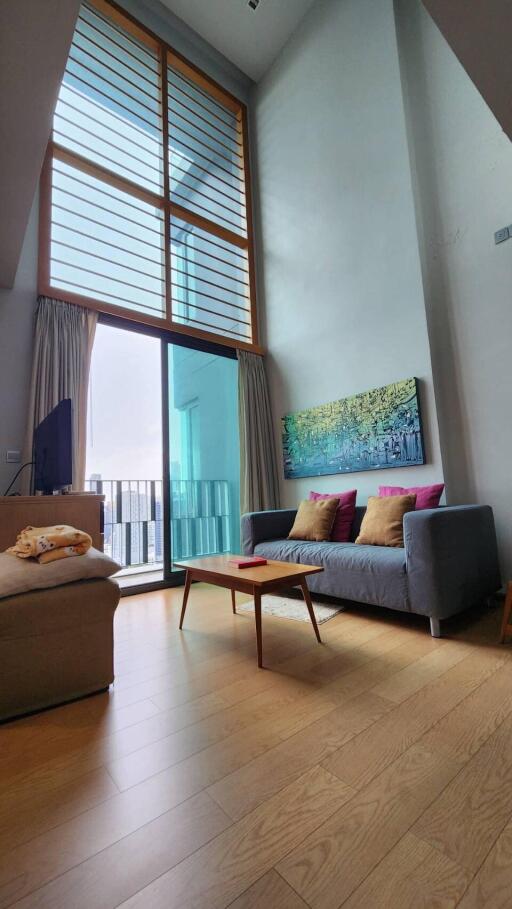 High-ceilinged modern living room with large windows