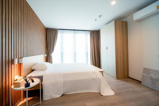 Modern bedroom with wood paneling and large window