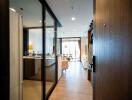 Modern apartment entryway leading to an open living space with kitchen.