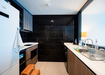 Modern kitchen with black tiled backsplash and wooden cabinets