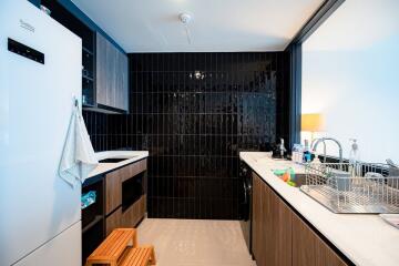 Modern kitchen with black tiled backsplash and wooden cabinets