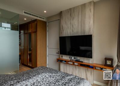 Modern bedroom with a wall-mounted TV and a wooden wardrobe