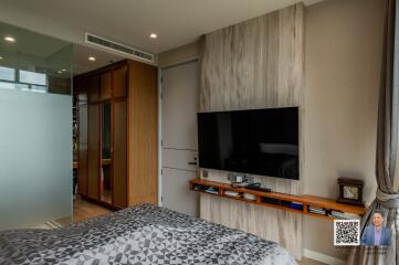 Modern bedroom with a wall-mounted TV and a wooden wardrobe