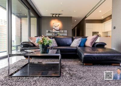 Modern living room with black leather sofa and glass coffee table