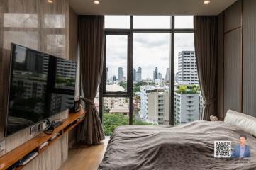 Modern bedroom with large windows and city view