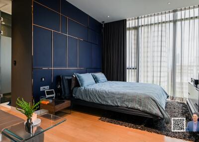 Modern bedroom with dark blue accent wall and large window