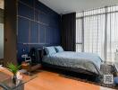 Modern bedroom with dark blue accent wall and large window