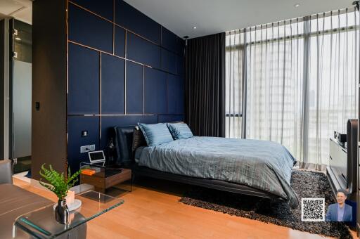 Modern bedroom with dark blue accent wall and large window