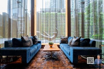 Modern living room with blue couches and large windows