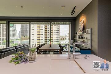 Modern living room with an open kitchen and large windows