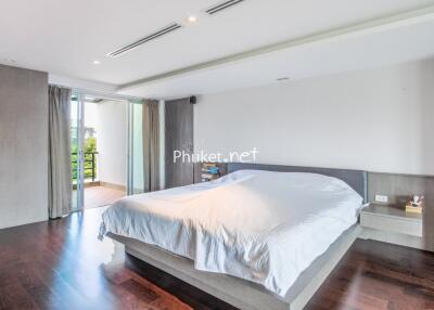 Modern bedroom with hardwood floors and balcony access