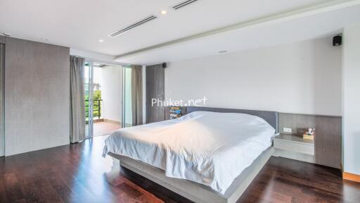 Modern bedroom with hardwood floors and balcony access