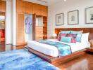 Spacious and modern bedroom with wooden flooring, stylish decor, and ample natural light.