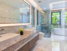 Modern bathroom with large vanity, shower, and bathtub with garden view