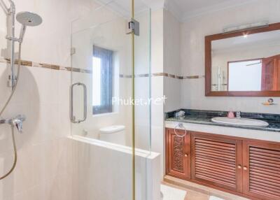 Bathroom featuring glass shower enclosure, sink with large mirror, and wooden vanity