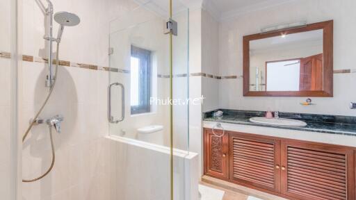 Bathroom featuring glass shower enclosure, sink with large mirror, and wooden vanity