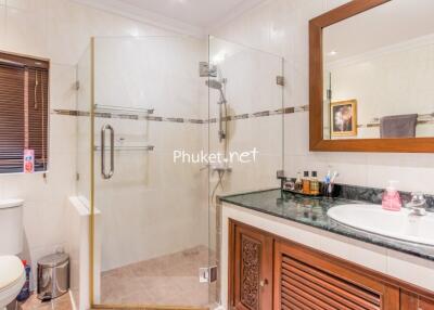 Modern bathroom with glass shower, toilet, and vanity area