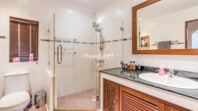 Modern bathroom with glass shower, toilet, and vanity area