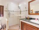 Modern bathroom with glass shower, toilet, and vanity area