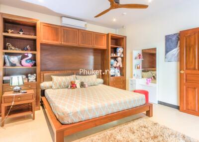 Spacious bedroom with wooden furniture and colorful decorations