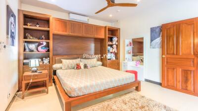 Spacious bedroom with wooden furniture and colorful decorations